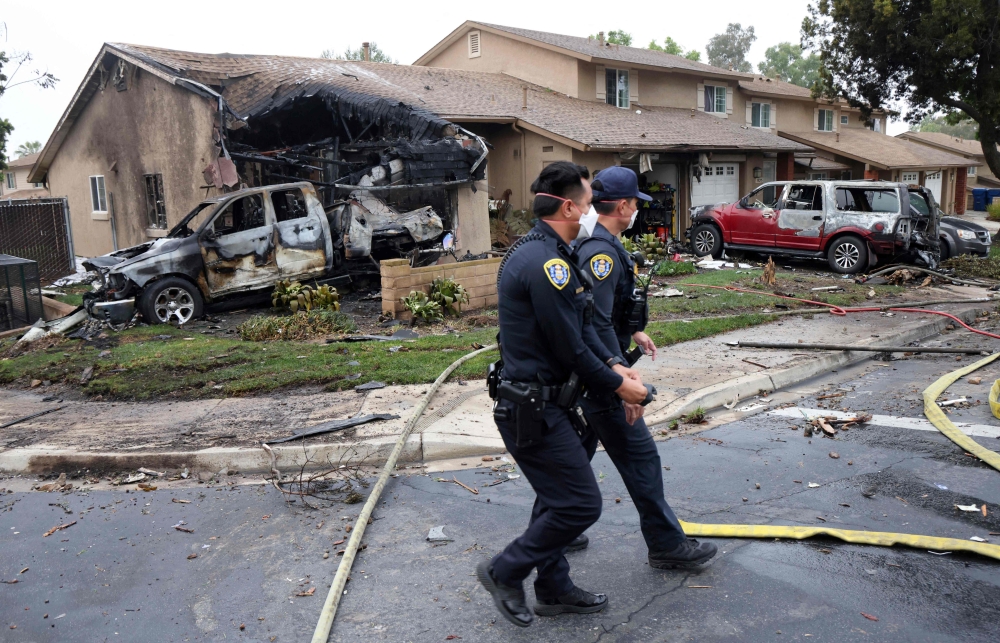 278453 Police officers search the site where a small plane crashed on a San Diego, California, residential street on May 22, 2025. — AFP pic