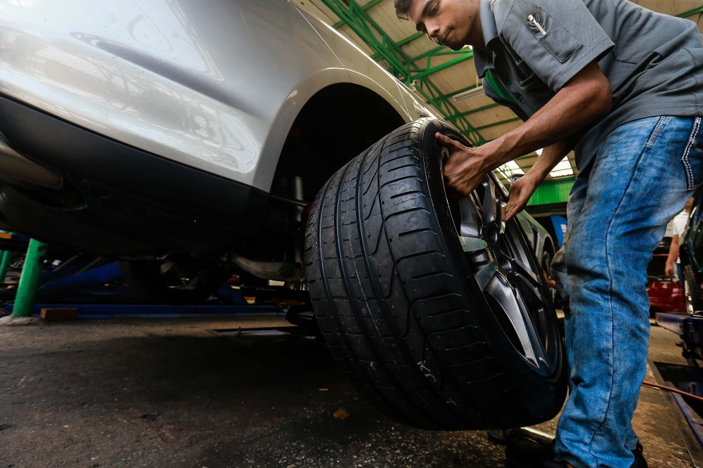 278506 A worker installs a tyre for a customer at Performance Tyre Malaysia in Shah Alam. — Picture by Sayuti Zainudin