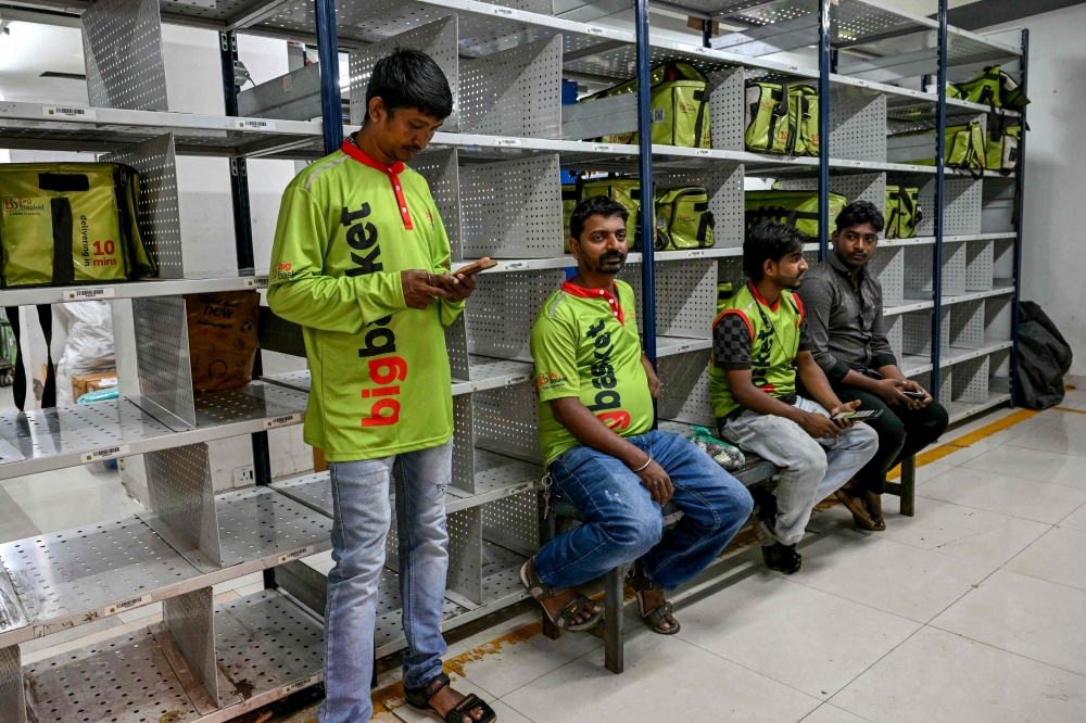 278992 Riders wait to collect customers’ orders for delivery at a BigBasket dark store in Mumbai March 21, 2025. — AFP pic