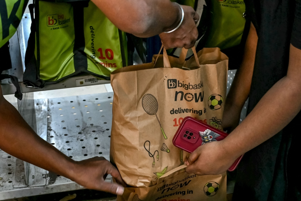 278993 A rider collects a customer’s order prepared for delivery at a BigBasket dark store in Mumbai March 21, 2025. — AFP pic
