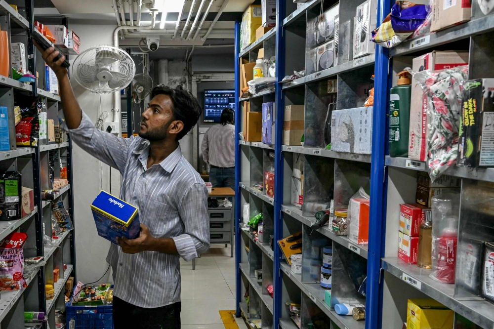 278996 A worker scans items while preparing a customer’s order for delivery at a BigBasket dark store in Mumbai March 21, 2025. — AFP pic