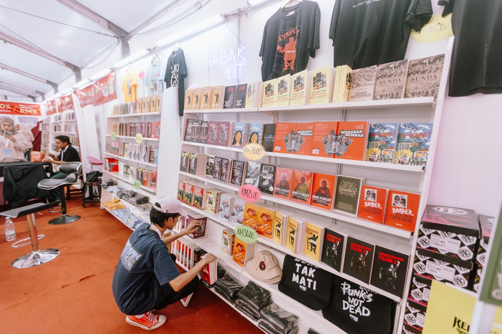 A staff member arranges books at the Rabak Lit booth during Kuala Lumpur International Book Fair 2025 at Kuala Lumpur. May 25, 2025 — Picture by Raymond Manuel