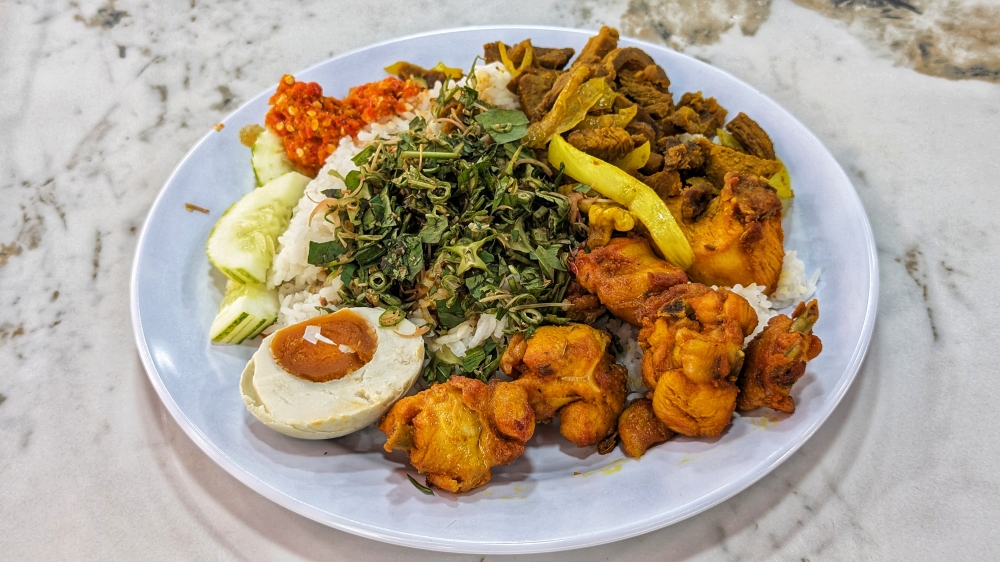 279698 A satisfying lunch of ‘nasi soho’ with ‘daging goreng kunyit’ and ‘telur masin’. — Picture by Ethan Lau