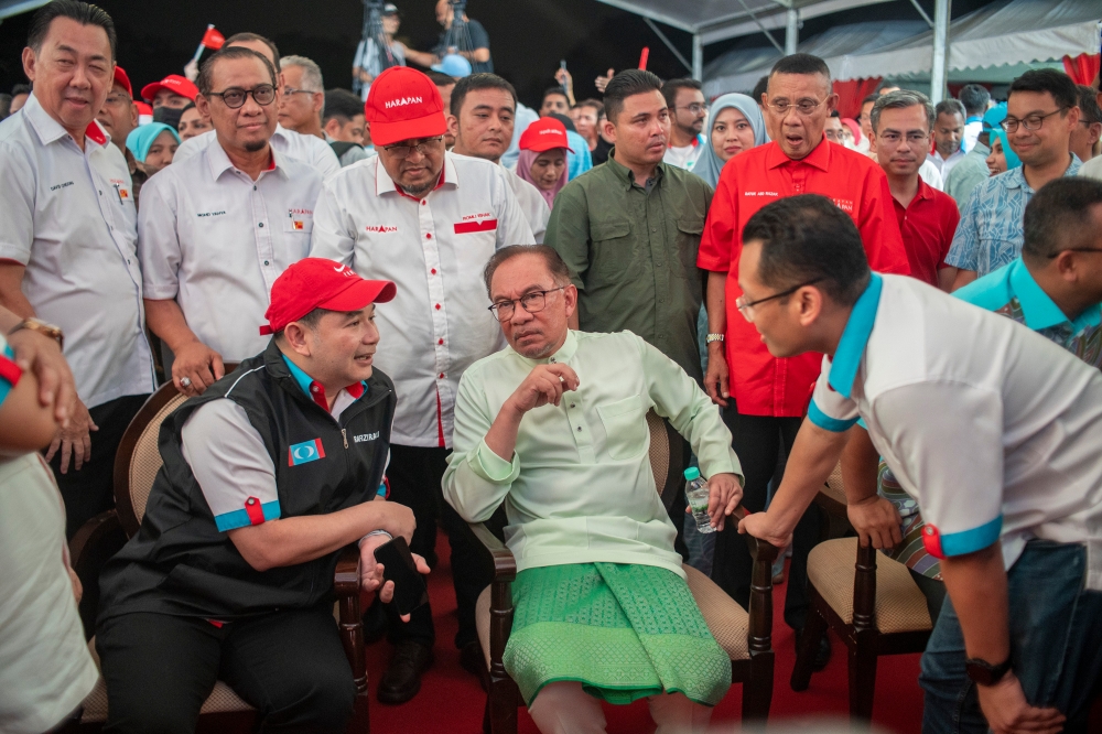 279710 PKR president Datuk Seri Anwar Ibrahim (centre), flanked by former deputy president Datuk Seri Rafizi Ramli (sitting left) and former vice-president Nik Nazmi Nik Ahmad (right). — Picture by Shafwan Zaidon