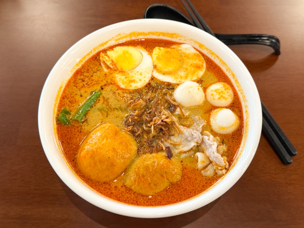 279831 Curry Panmee is a fiery bowl loaded with beancurd puff, hard boiled egg, fish balls, pork belly slices and long beans. — Picture by Lee Khang Yi