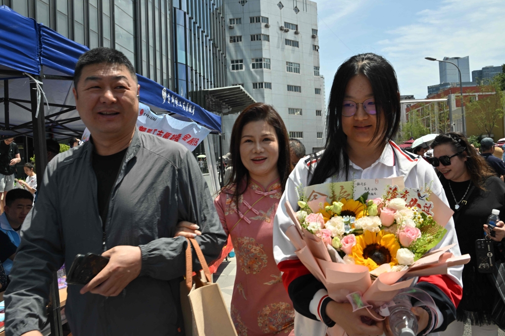 Hopeful parents accompanied their teenage children to the gates of a busy Beijing test centre on Saturday, among millions of high school students across China sitting their first day of the highly competitive university entrance exam. — AFP pic