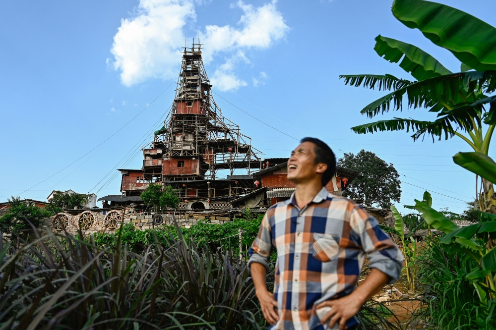 This picture taken on May 20, 2025 shows Chen Tianming standing in front of his house labelled China's strangest
