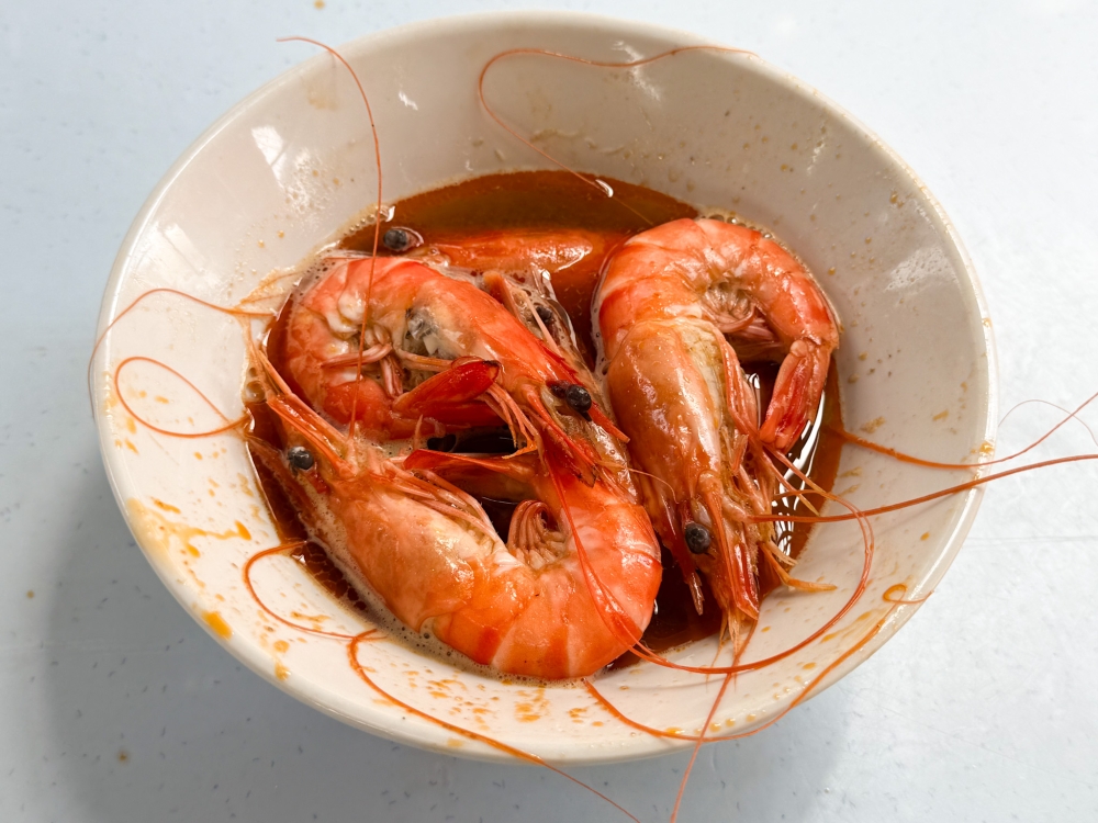 The prawns are slowly cooked in the prawn and pork broth to infuse it with more flavour.