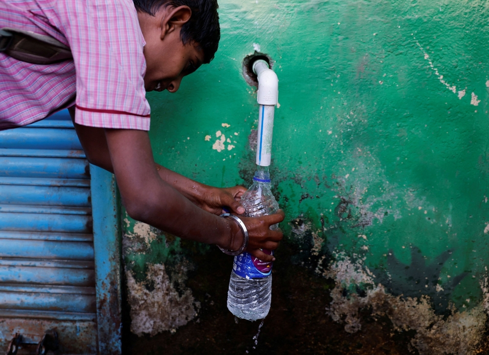 A boy fills a bottle with water from a water ATM machine in Solapur, India, March 3, 2025. — Reuters pic