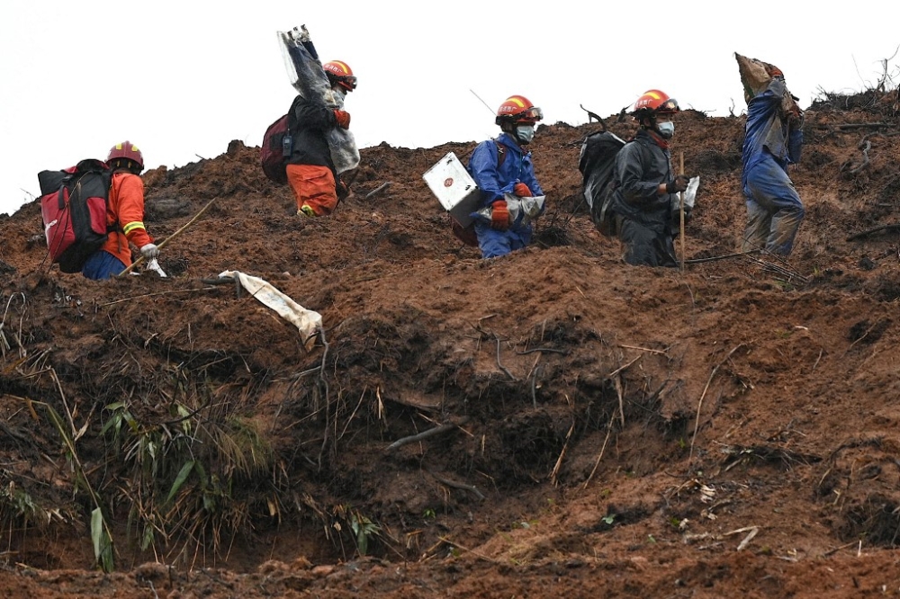 This file photo taken on March 24, 2022 shows rescue workers combing through the site of where China Eastern flight MU5375 crashed on March 21, near Wuzhou in southwestern China’s Guangxi province. — AFP pic