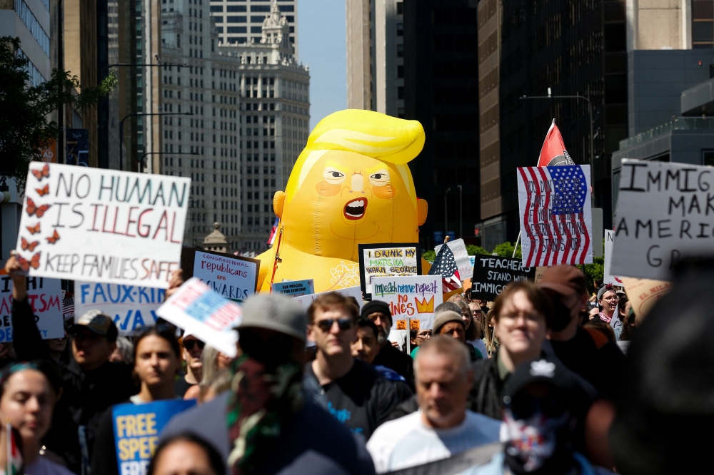 People gather near a balloon depicting US President Donald Trump during the No Kings rally to protest against Trump’s policies in Chicago, Illinois June 14, 2025. — Reuters pic