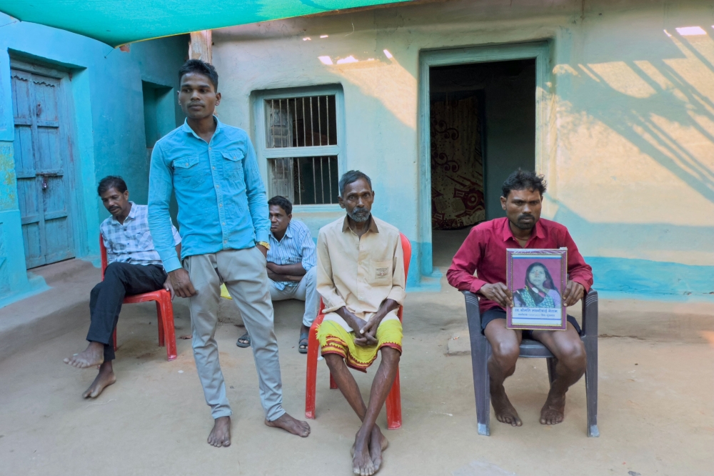 271890-1 Farmer Mohan Singh Gond holds the portrait of his late mother Lakshmibai Gond, who was trampled by elephants while watching her fields, as he sits next to his family members at their house in Gariaband district in India’s Chhattisgarh state March 12, 2025. — AFP pic