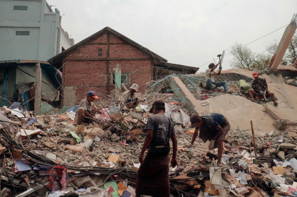 272166-3 People sort through the rubble of a collapsed building in Mandalay on April 5, 2025, following the March 28 earthquake. — AFP pic