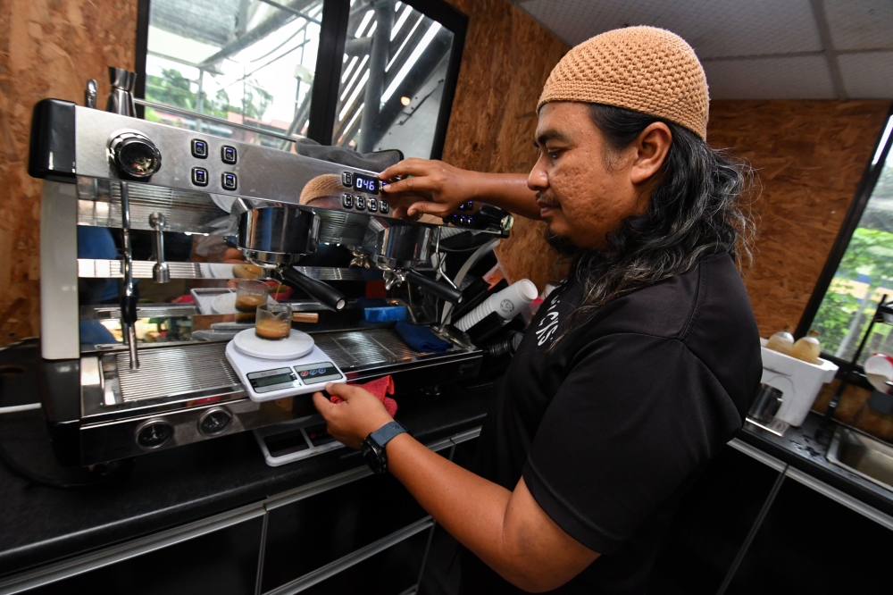 272324 Kopi Kaktus owner Mazuadi Zakaria demonstrates how ‘Tuwokano’, also known as tuak coffee, is made when met by Bernama at Kedai Bunga Suri, Jalan Pasir Hor in Kota Baru April 20, 2025. — Bernama pic