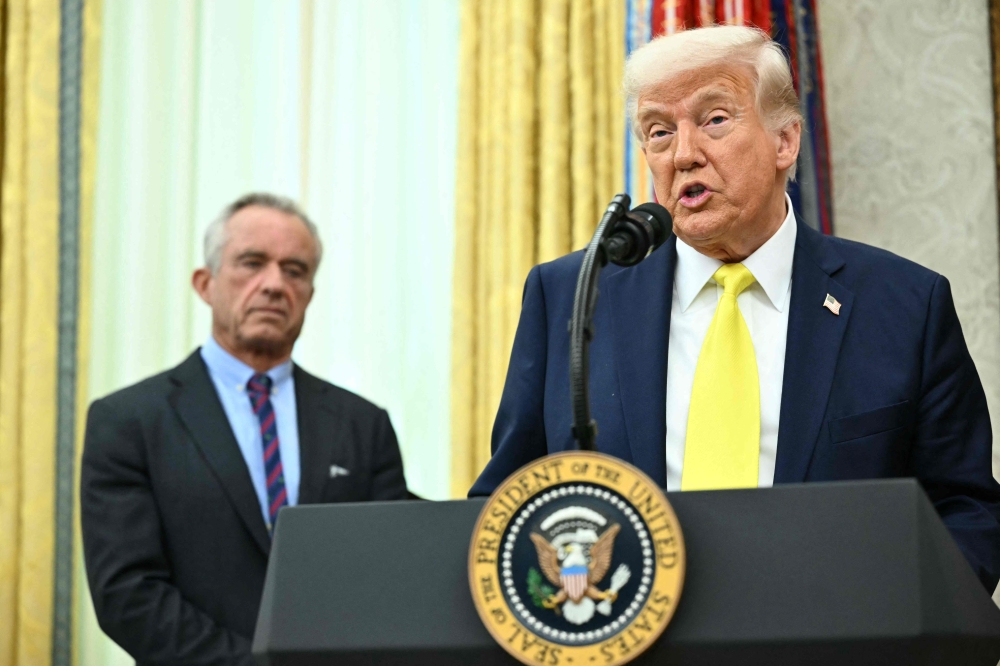 272346 US President Donald Trump speaks after the swearing in of Mehmet Oz as the administrator of the Centres for Medicare and Medicaid Services as Health and Human Services Secretary Robert F. Kennedy Jr. (left) looks on in the Oval Office of the White House in Washington, DC April 18, 2025. — AFP pic