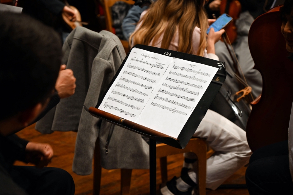 Renowned composer and head of the department of musicology and composition at the Kyrgyz National Conservatory, Balasaguyn Musayev, who participates in a competition to create a new national anthem for Kyrgyzstan, observes the orchestra of the Kyrgyz National Conservatory performing his composition for the contest in Bishkek on April 4, 2025. — AFP pic