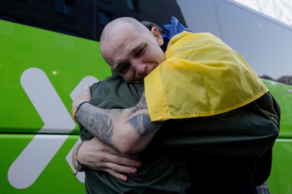 272391 A freed Ukrainian prisoner hugs a loved-one after an exchange of prisoners at an undisclosed location in Ukraine on April 19, 2025, amid the Russian invasion of Ukraine. — AFP pic