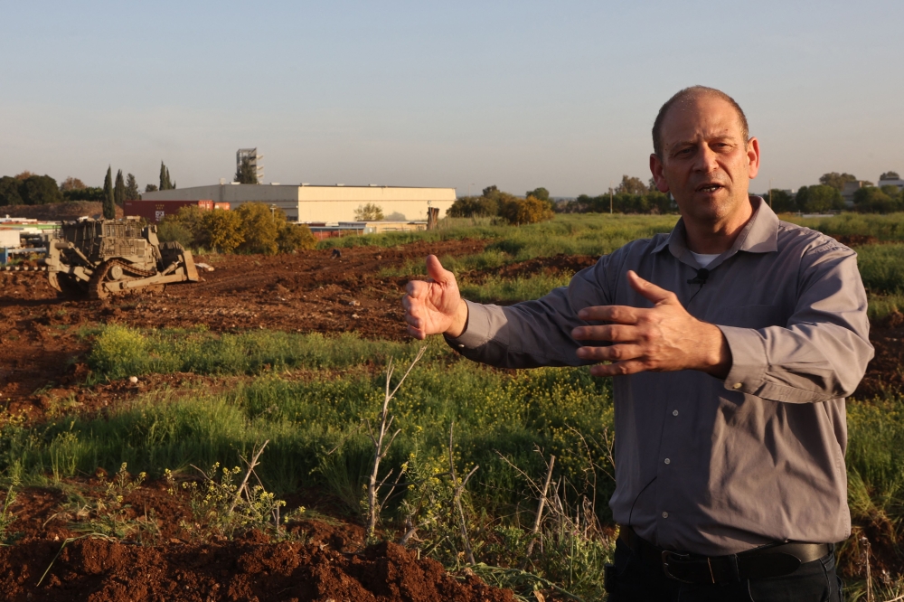 272399 An engineer of the Israel Aerospace Industries (IAI) explains how unmanned D9 military bulldozers operate during a demonstration to the press in a field near Tel Aviv on March 26, 2025. — AFP pic