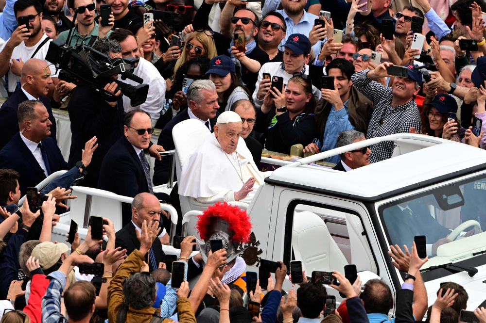 Pope Francis waves to the crowd from the popemobile after the Easter mass, at St Peter's square in the Vatican April 20, 2025. — AFP pic