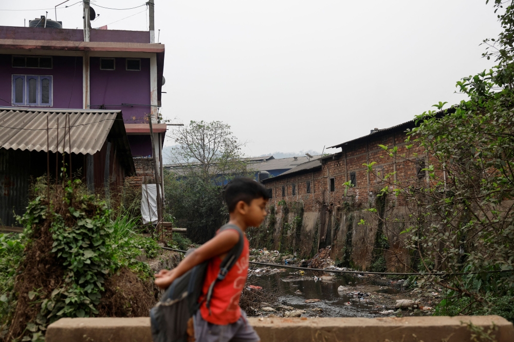 272453 A boy walks past a polluted water stream in the town of Brynihat, ranked world’s most polluted metropolitan area by Swiss Group IQAir, in India, March 27, 2025. — Reuters pic