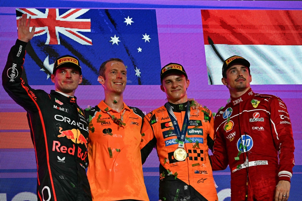 272473 McLaren's Australian driver Oscar Piastri (2nd right) celebrates on the podium alongside second-placed Red Bull Racing's Dutch driver Max Verstappen (left) and third-placed Ferrari's Monegasque driver Charles Leclerc (right), during the trophy ceremony of the 2025 Saudi Arabia Formula One Grand Prix at the Jeddah Corniche Circuit April 20, 2025. — AFP pic