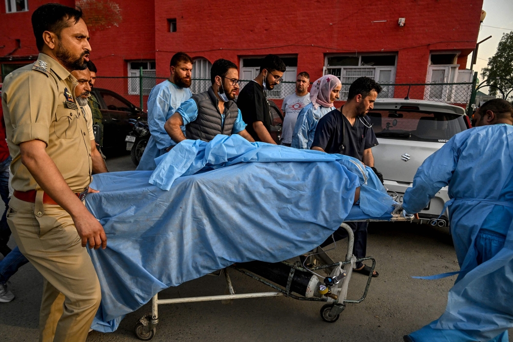 Paramedics and police personnel carry an injured tourist at a hospital in Anantnag, south of Srinagar, on April 22, 2025, following an attack. — AFP pic