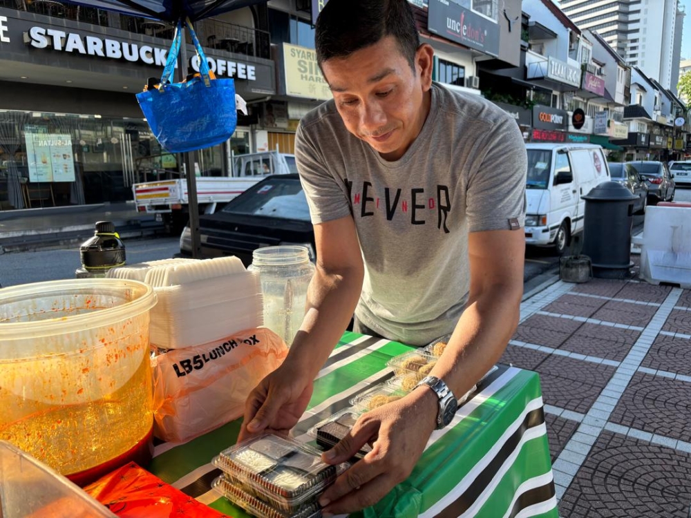 273655 Mohd Adam bin Atan increased the price of ‘kuih tepung pelita’ from RM0.60 to RM0.80 last month, but he says another price hike is imminent in the coming weeks. — Picture by Dhesegaan Bala Krishnan