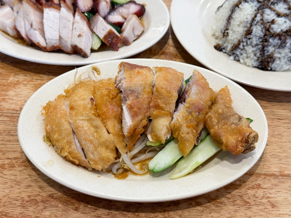 273752 Join the crowd and order the fried chicken drumstick rice where your fried chicken is expertly chopped and served on a bed of bean sprouts and cucumbers. — Picture by Lee Khang Yi