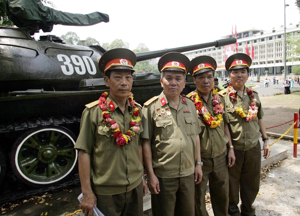 273834 (From left) Le Van Phuong, Vu Dang Toan, Nguyen Van Tap and Ngo Sy Nguyen, the four-man crew of Tank 390, the first to crash through the gates of Saigon’s presidential palace on April 30, 1975, pose next to a tank of the same type on display at the palace in Ho Chi Minh City on April 28, 2005. — AFP pic