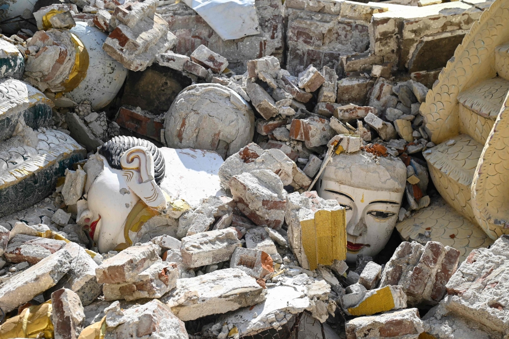273843 Damaged Buddha statues are surrounded by the debris of a collapsed building in Mandalay April 12, 2025, following the devastating March 28 earthquake. — AFP pic