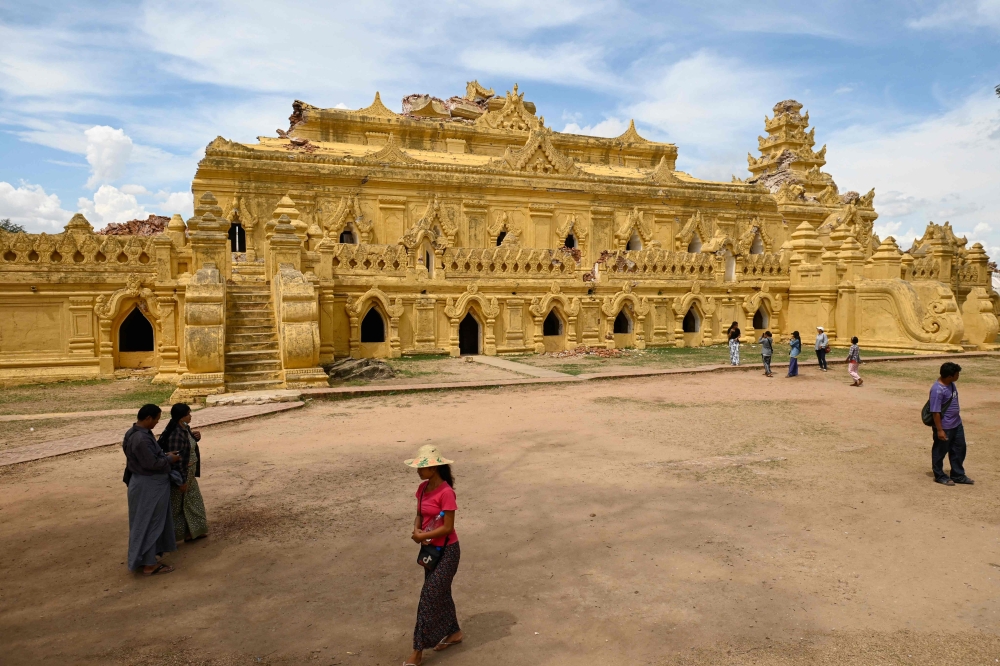 273845 People walk past the damaged Me Nu Brick Buddhist monastery in Inwa on the outskirts of Mandalay April 12, 2025, following the devastating March 28 earthquake. — AFP pic