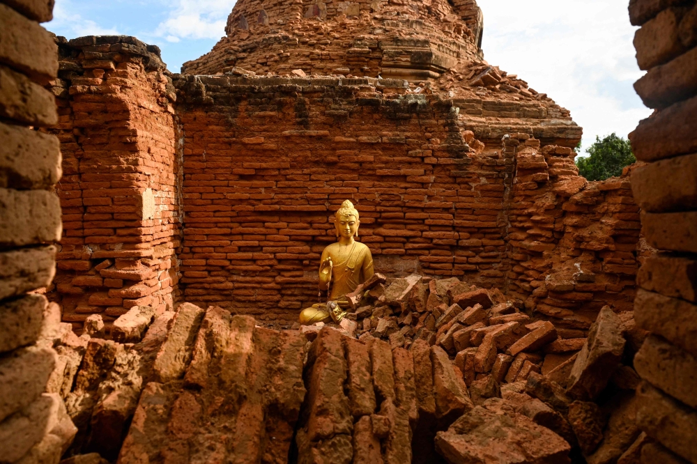 273846 A damaged Buddha statue surrounded by debris in Inwa on the outskirts of Mandalay April 12, 2025, following the devastating March 28 earthquake. — AFP pic