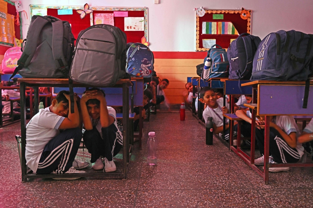 275541 As border tensions surge, students take part in an emergency mock drill as part of the nationwide civil defence mock drill at a school in New Delhi today. — AFP pic