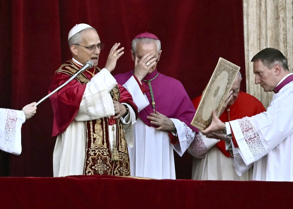275842 Newly elected Pope Leo XIV, Robert Prevost (left) addresses the crowd on the main central loggia balcony of the St Peter's Basilica for the first time, after the cardinals ended the conclave, in The Vatican, on May 8, 2025. A moderate who was close to Pope Francis and spent years as a missionary in Peru, he becomes the Catholic Church's 267th pontiff, taking the papal name Leo XIV. — AFP pic