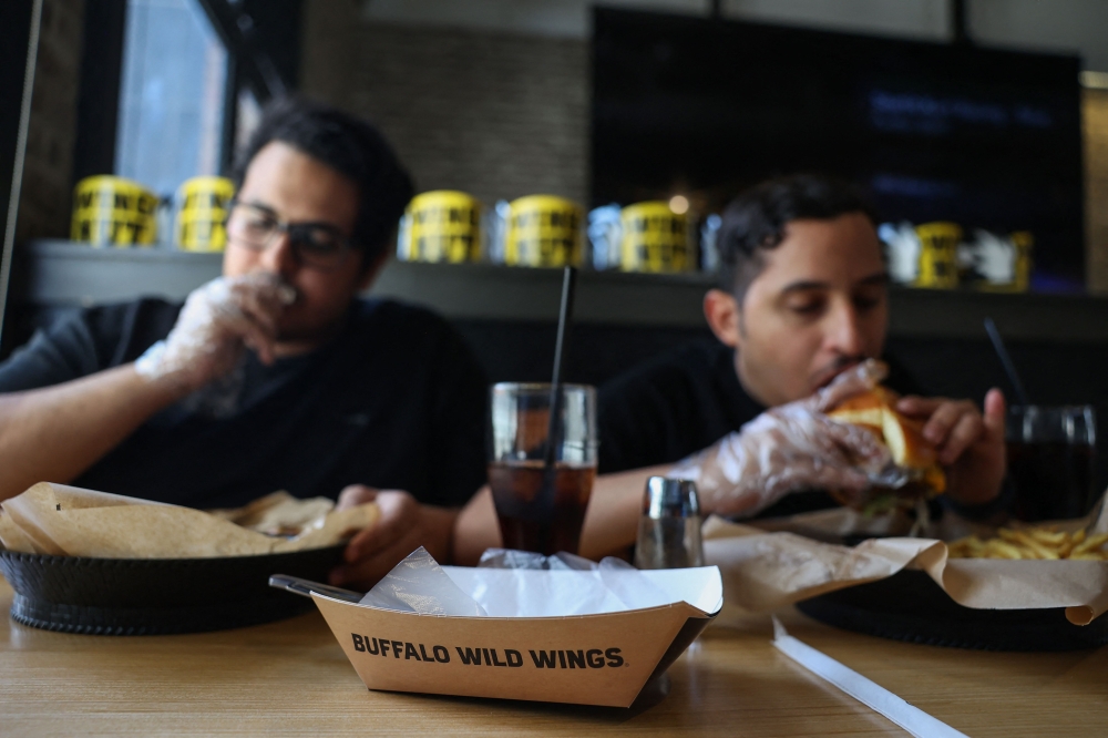 275928 Saudis have a meal at a branch of the US restaurant 'Buffalo Wild Wings' in Riyadh on May 1, 2025. — AFP pic