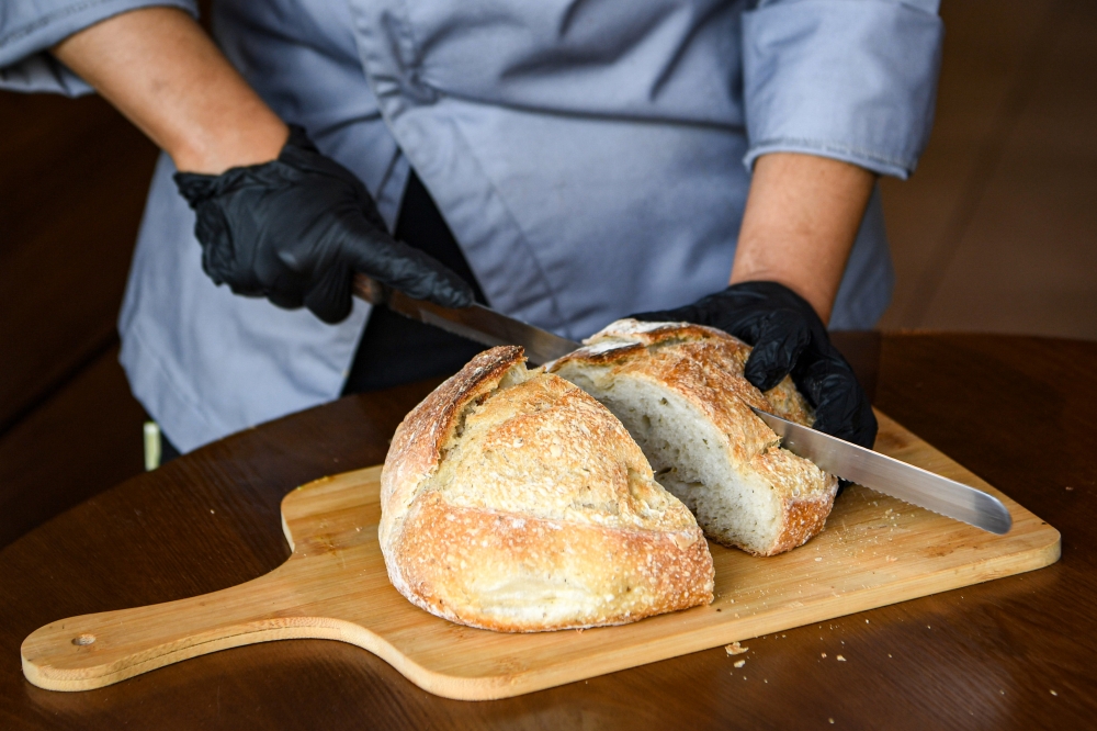 276381 Fresh sourdough bread being sliced at Yin’s Sourdough Bakery & Cafe, Kuala Lumpur. — Bernama pic