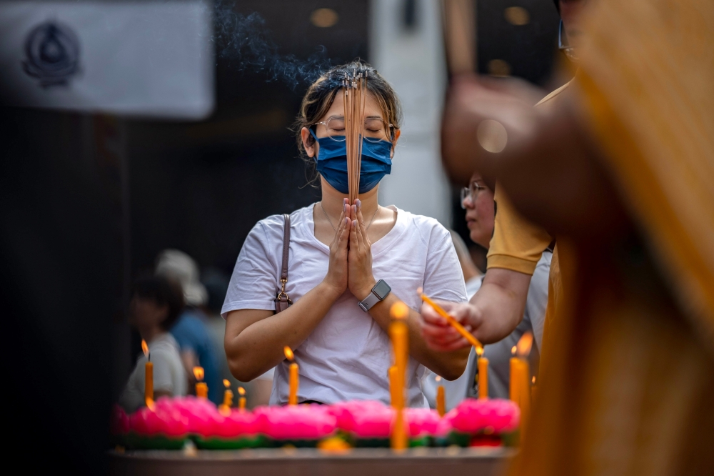 276484 A woman says her prayers while holding incense sticks as part of Wesak Day celebrations at the Maha Vihara Temple in Brickfields, Kuala Lumpur today. — Bernama pic