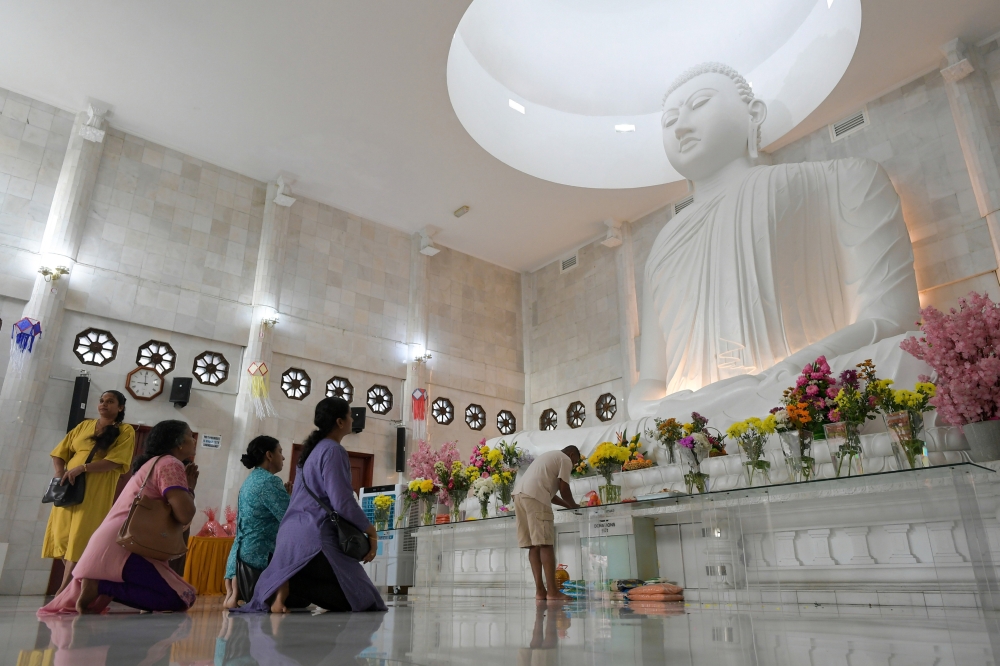 276488 Visitors kneel before a statue of Buddha during the Wesak Day celebration at the Sri Lanka Buddhist Temple in Sentul, Kuala Lumpur today. — Bernama pic