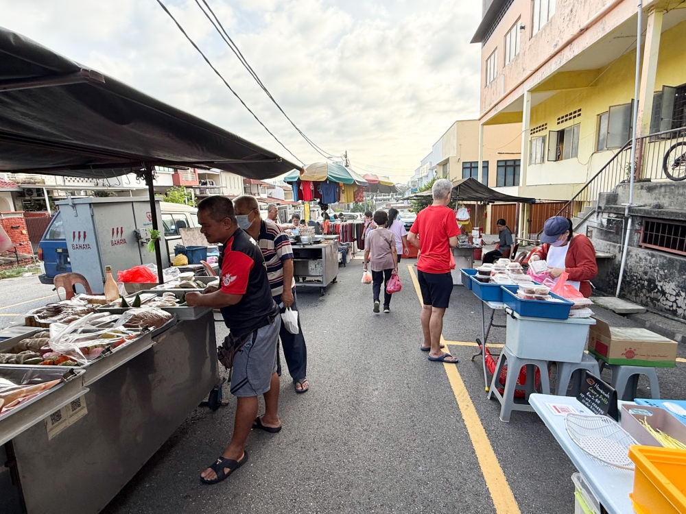 276784 The stalls along this road next to the Sea Park market have been feeding many with its food.