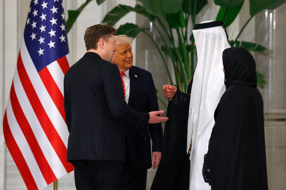277009 US President Donald Trump speaks with Tesla CEO Elon Musk and Qatar's Emir Tamim bin Hamad Al Thani ahead of a state dinner at Lusail Palace in Lusail, Qatar, May 14, 2025. — Reuters pic